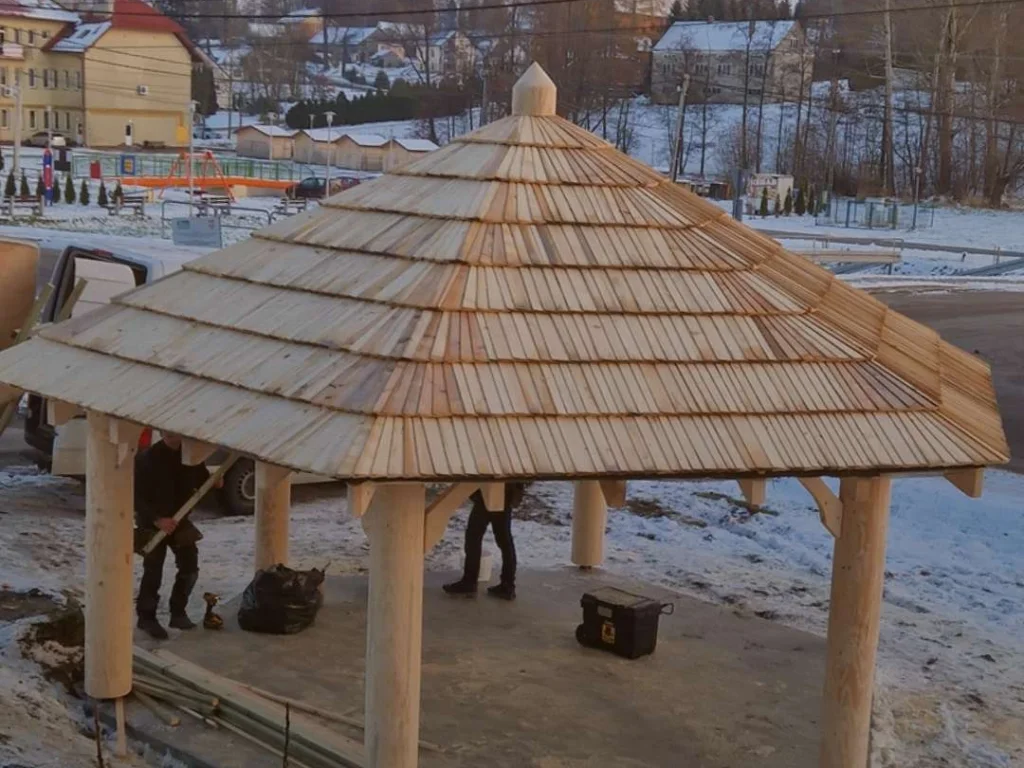 Wiata z czterospadowym dachem z nowego gontu drewnianego, zimowa sceneria